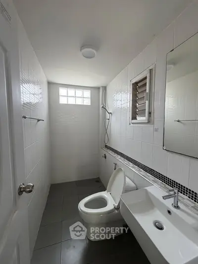 Compact bathroom with modern fixtures and natural light