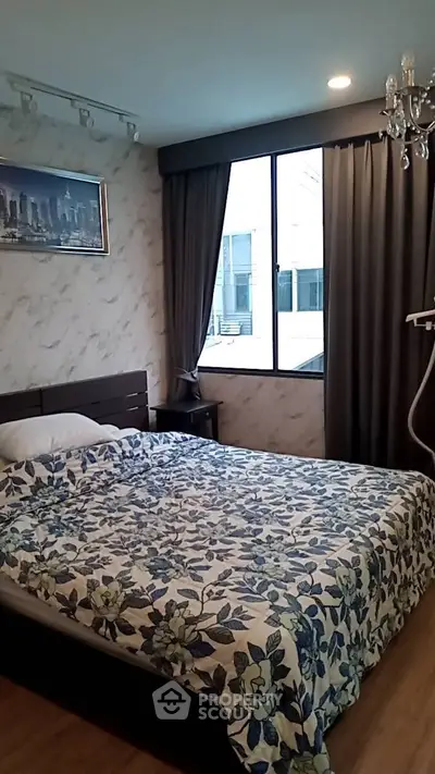 Cozy bedroom with floral bedding and large window for natural light