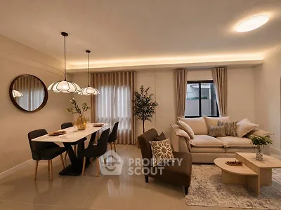 Elegant living room with modern dining area and cozy seating, featuring stylish lighting and decor.