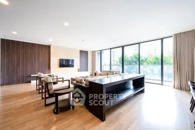 Spacious modern living room with large windows and elegant wooden flooring.