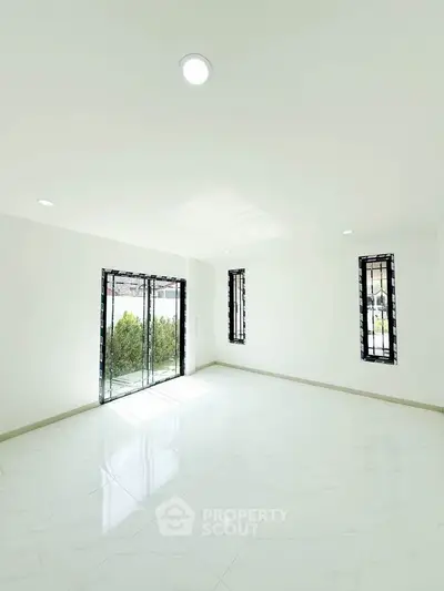 Spacious and bright living room with large windows and modern design, perfect for natural light lovers.