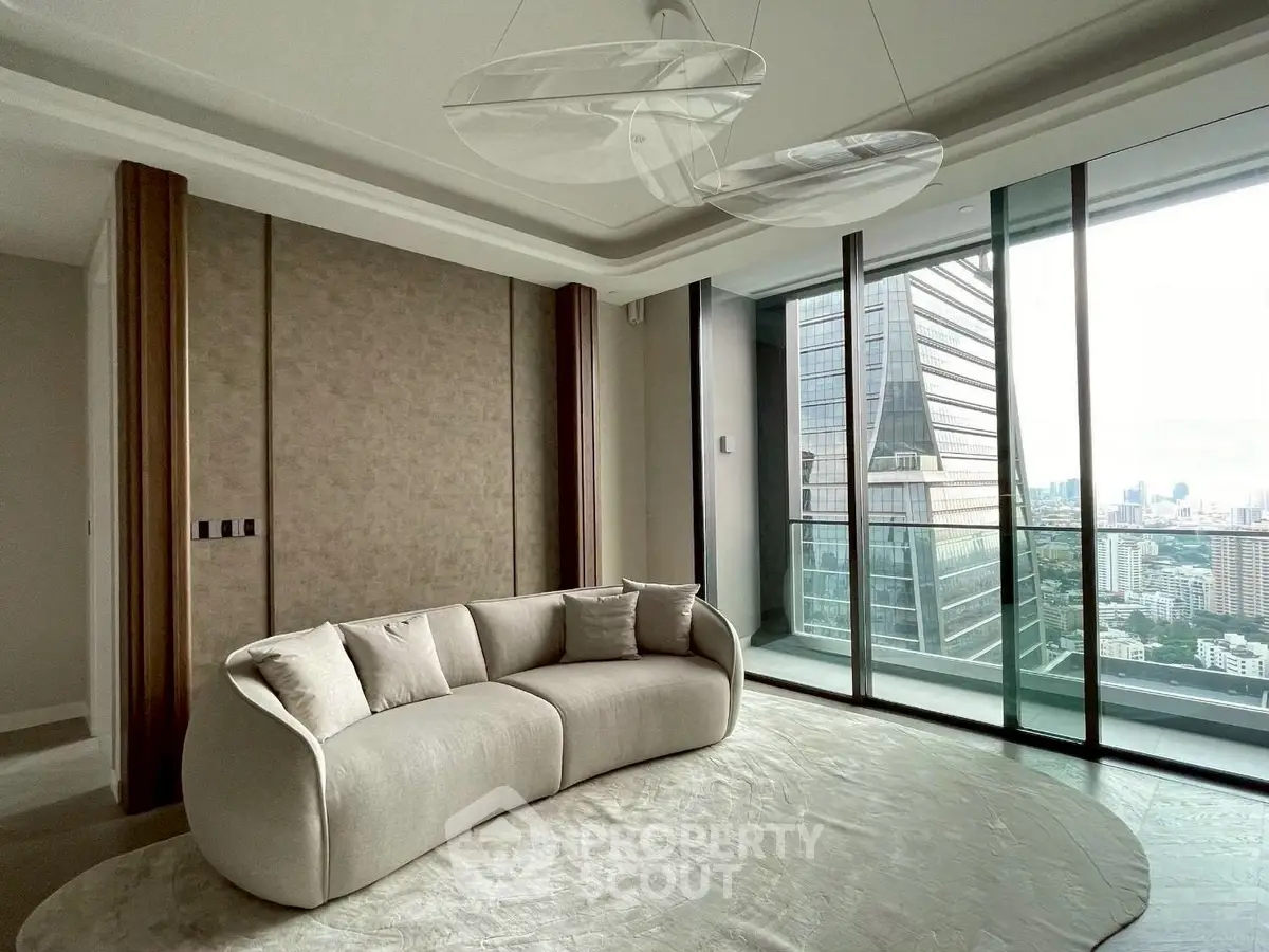 Luxurious living room with modern sofa and stunning city view from floor-to-ceiling windows.