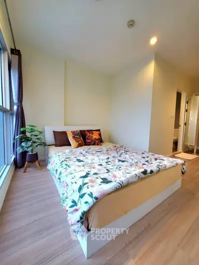 Spacious bedroom with modern decor and large window for natural light