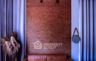 Stylish living room with exposed brick wall and leather sofa