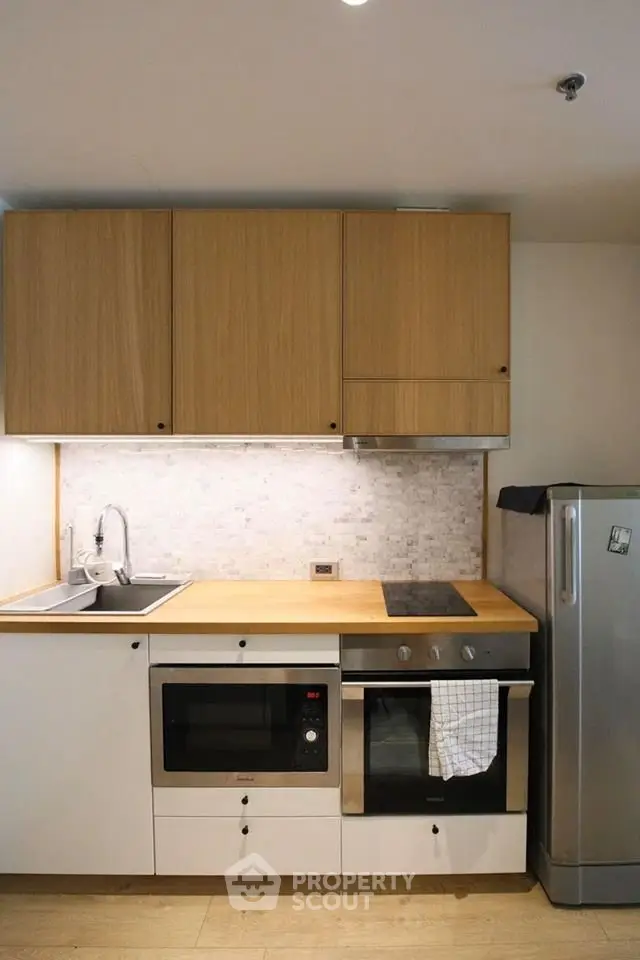 Modern kitchen with sleek appliances and wooden cabinetry, perfect for culinary enthusiasts.