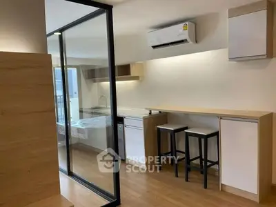 Modern studio apartment with sleek kitchen and glass partition