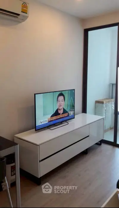 Modern living room with sleek TV stand and balcony access, perfect for urban living.