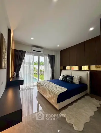 Luxurious bedroom with pool view, elegant decor, and natural light for a serene living experience.
