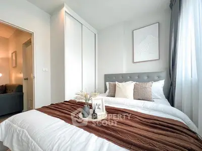 Modern bedroom with stylish decor and natural light, featuring a cozy bed and elegant furnishings.
