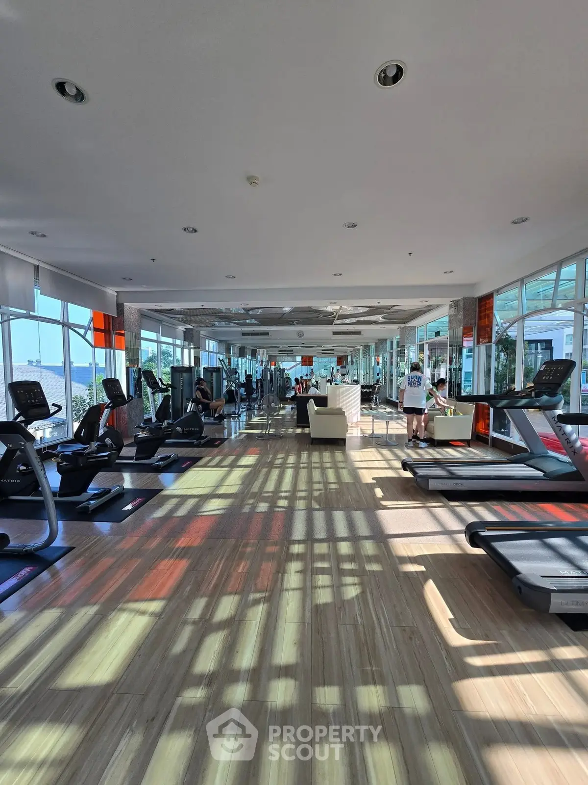 Spacious gym with modern equipment and panoramic windows offering stunning views.