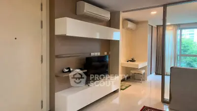 Modern living room with sleek white furniture and large windows offering natural light.