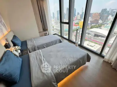 Luxurious bedroom with stunning city view and modern twin beds in high-rise apartment.