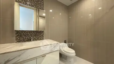 Luxurious modern bathroom with marble countertop and elegant tile design.