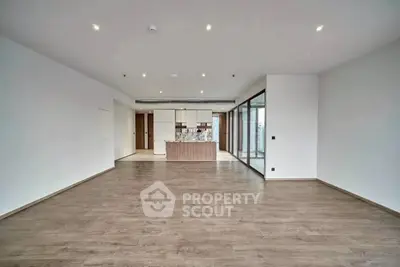Spacious modern living room with open kitchen and wooden flooring