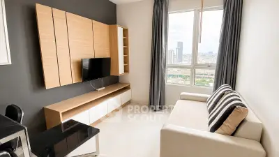 Modern living room with sleek furniture and city view from large window.