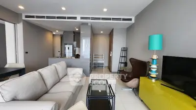 Modern living room with stylish furniture and open kitchen layout in a contemporary apartment.