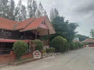Charming traditional-style homes line a peaceful street, boasting terracotta roofs, lush greenery, and inviting brick fences, perfect for serene living.