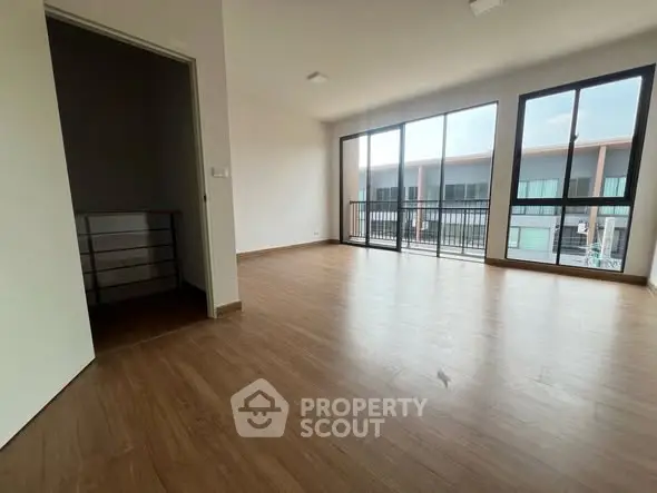 Spacious modern living room with large windows and wooden flooring