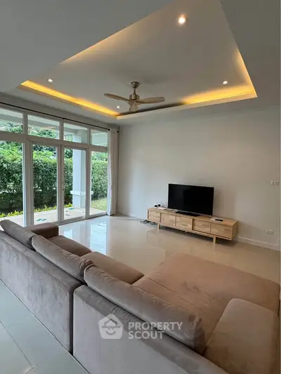 Spacious living room with modern sofa and garden view, perfect for relaxation.