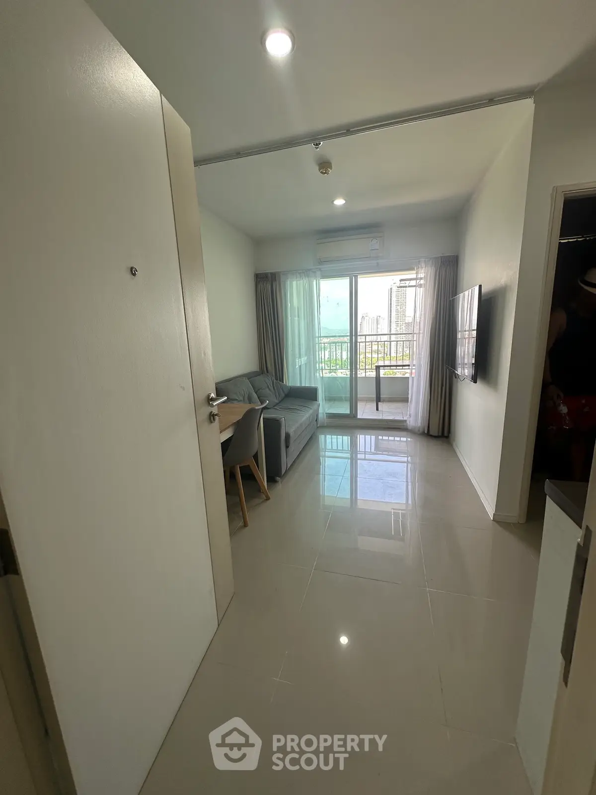 Modern living room with sleek furniture and balcony view in a stylish apartment.
