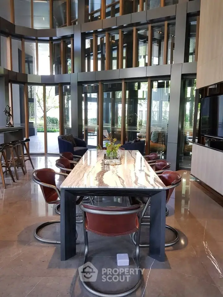 Luxurious modern dining area with elegant marble table and stylish chairs in a high-ceilinged room.
