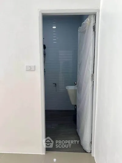 Minimalist bathroom with white walls and simple fixtures, ideal for compact spaces.
