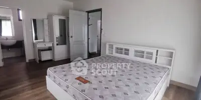 Spacious bedroom with modern furniture and ensuite bathroom in a stylish home.