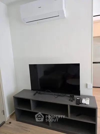 Modern living room with sleek TV setup and air conditioning unit, perfect for comfortable living.