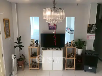 Cozy living room with modern decor and elegant chandelier lighting.