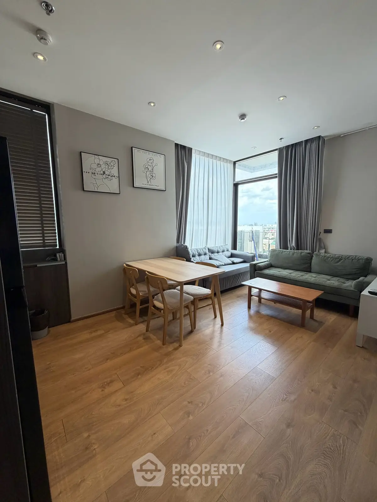Modern living room with large windows and stylish furniture, offering a cozy and inviting atmosphere.