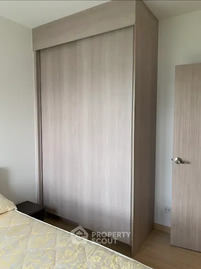 Modern bedroom with sleek wooden wardrobe and cozy bed setup