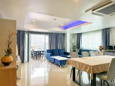 Spacious modern living room with elegant dining area and large windows offering natural light.
