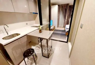 Modern compact kitchen with sleek design and integrated appliances in a stylish apartment.