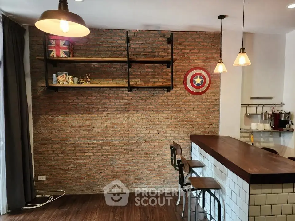 Stylish kitchen with brick wall and modern lighting, featuring a cozy bar area.