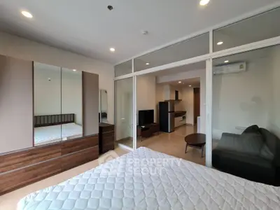 Modern studio apartment with glass partition and stylish furnishings