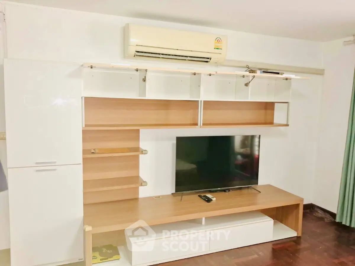 Modern living room with sleek TV unit and air conditioning, perfect for comfortable living.