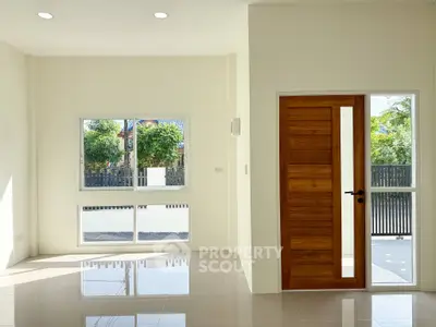 Bright modern living room with large windows and wooden door, perfect for natural light lovers.