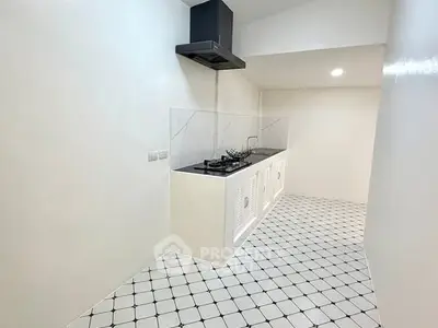 Modern minimalist kitchen with sleek gas stove and white tiled flooring