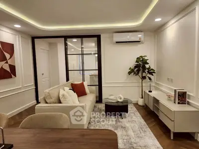 Modern living room with stylish decor and air conditioning, featuring a cozy sofa and elegant lighting.