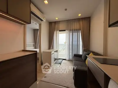 Modern living room with balcony view, cozy sofa, and elegant decor in a stylish apartment.