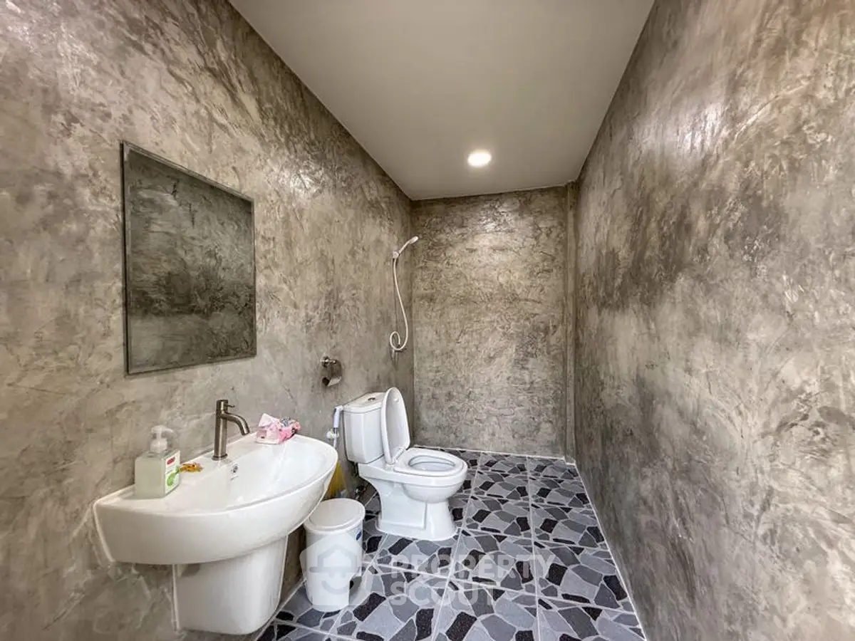 Modern minimalist bathroom with concrete walls and geometric floor tiles