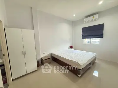 Spacious bedroom with modern furnishings and air conditioning unit