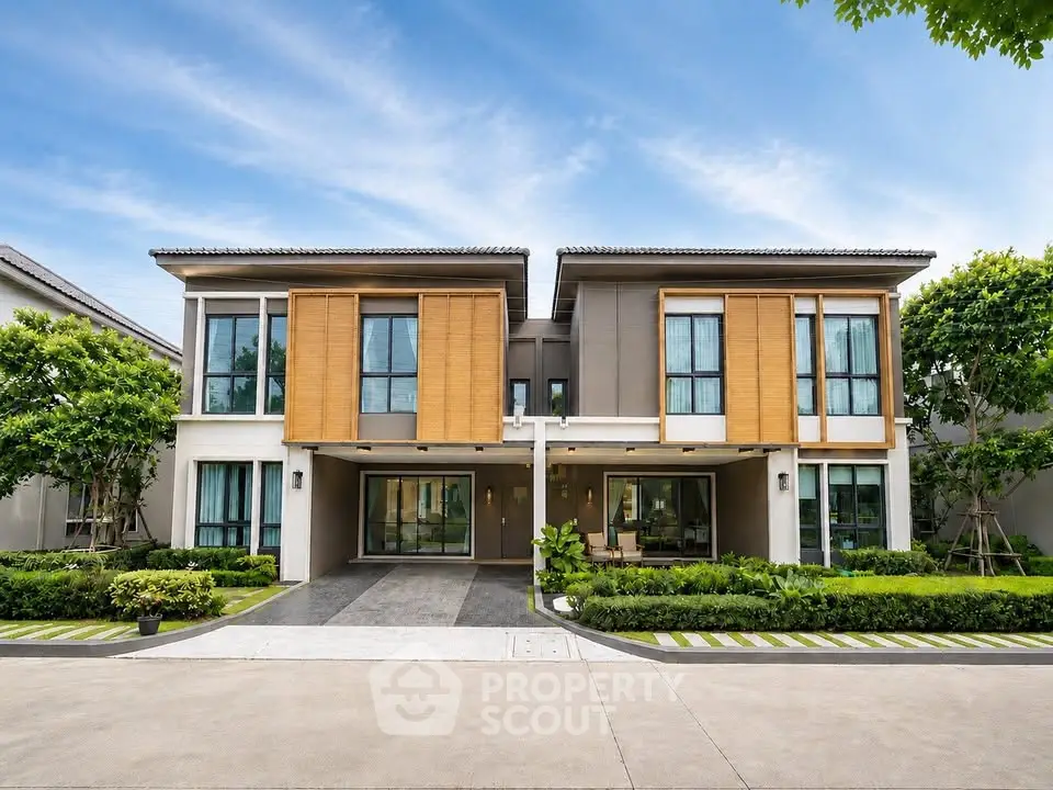 Stunning modern two-story house with lush landscaping and large windows