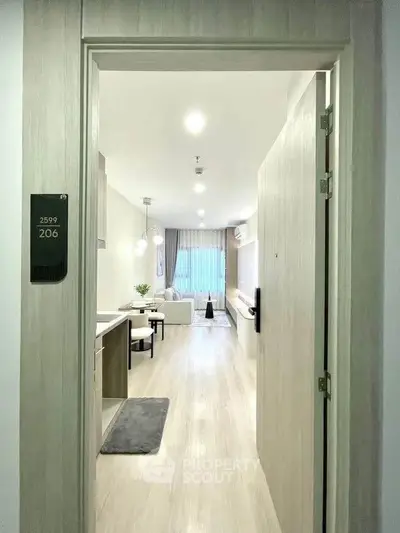 Modern apartment entrance leading to a stylish living room with sleek decor and ample natural light.