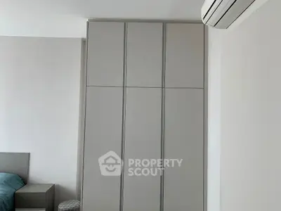 Modern bedroom with sleek wardrobe and air conditioning unit