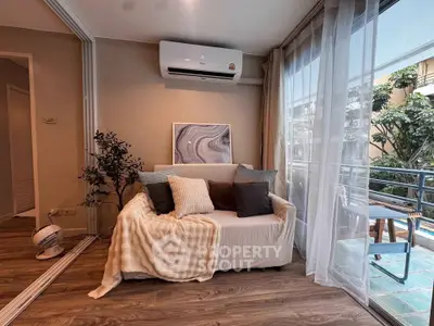 Cozy living room with modern decor and balcony view, featuring a comfortable sofa and air conditioning.