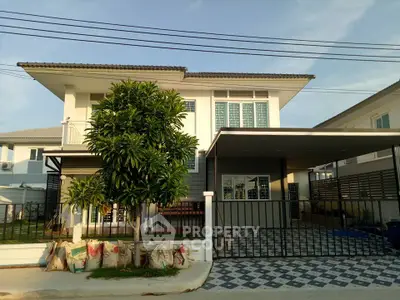 Modern two-story house with spacious driveway and lush greenery, perfect for family living.