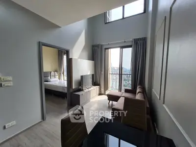 Modern apartment with high ceilings and large windows offering stunning city views, featuring a cozy living area and bedroom.