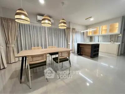 Modern dining area with stylish lighting and open kitchen layout