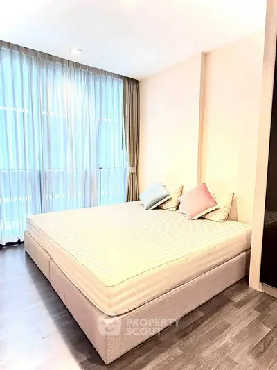 Spacious bedroom with large windows and elegant decor, perfect for relaxation and comfort.
